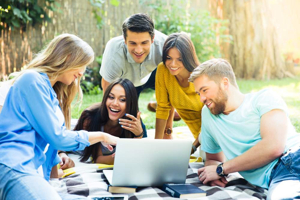 a group around a laptop in the garden