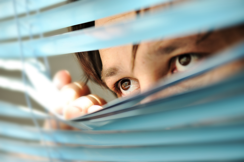 Person looking out blinds - audience feel like they are being spied on.