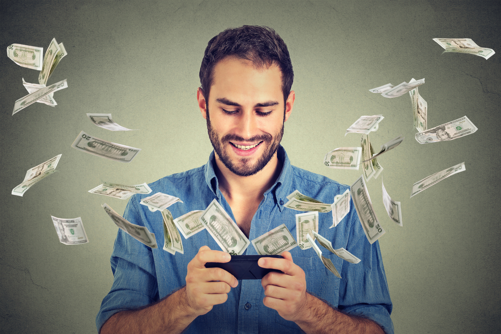 man with smart phone showing money flowing